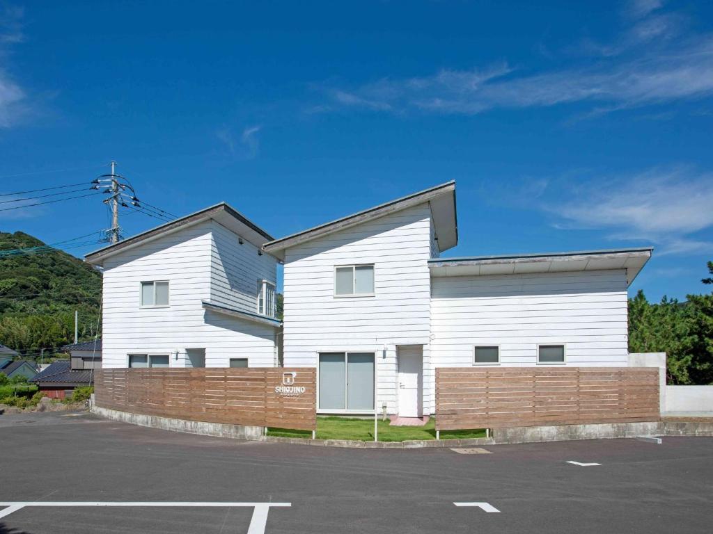 a white building with a fence in front of it at Sauna & Cottage SHIOJINO - Vacation STAY 06218v in Karatsu