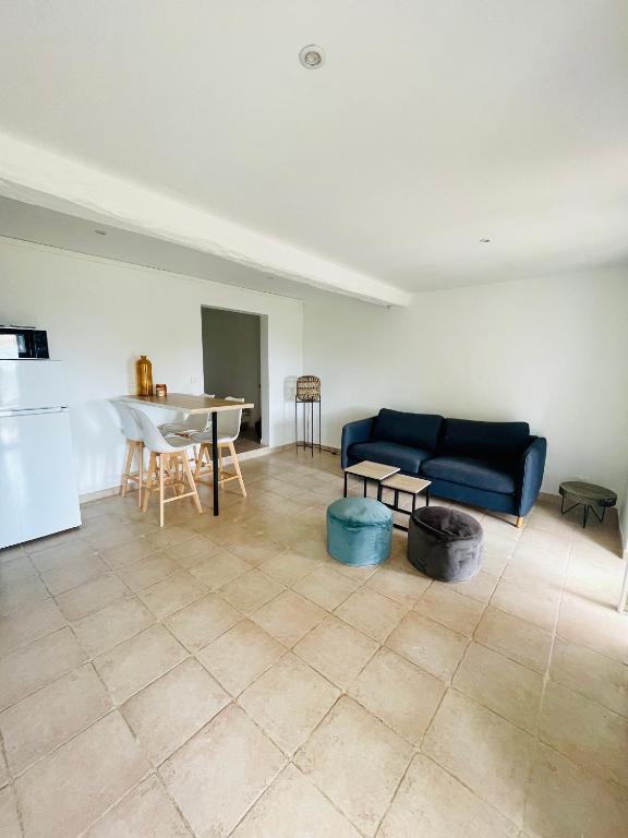 un salon avec un canapé bleu et une table dans l'établissement Maison corse au calme, à Porto-Vecchio