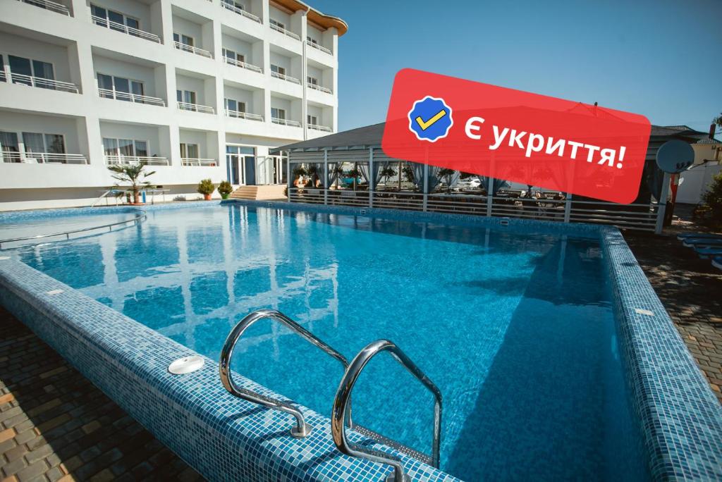 a swimming pool in front of a hotel at Villa Santorini in Zatoka