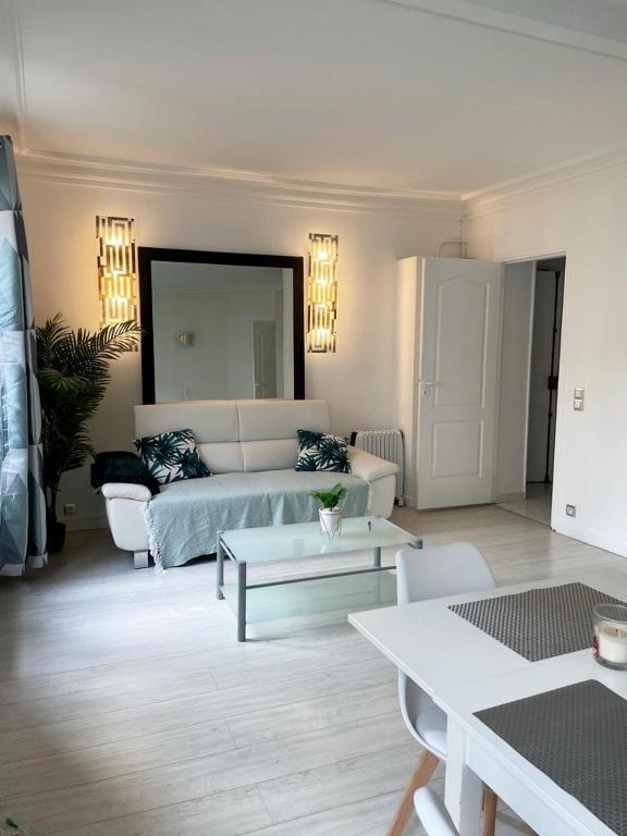 un salon avec un canapé et une table dans l'établissement Appartement 75017 proche Parc Monceau, à Paris