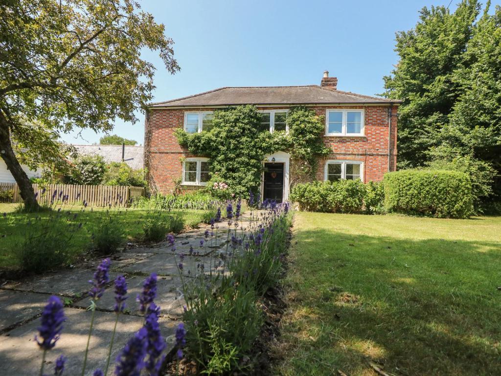 a house with purple flowers in the front yard at Guildford Farmhouse in Ryde