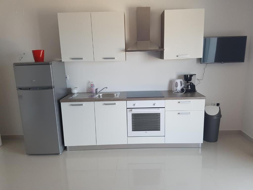 a white kitchen with a sink and a refrigerator at Apartments Tereza in Senj
