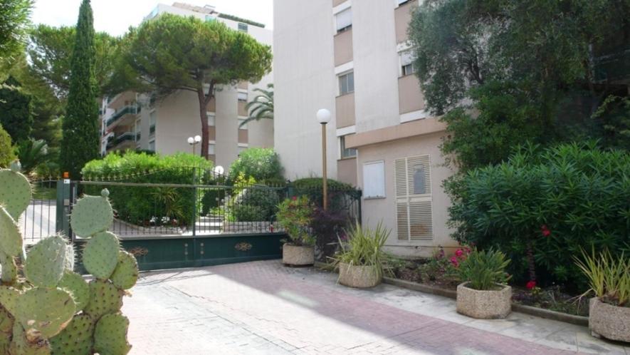 un bâtiment avec beaucoup de plantes dans une cour dans l'établissement Appartement le Saint James, à Nice