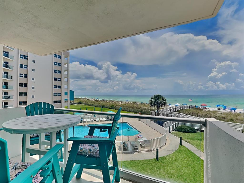 a balcony with a table and chairs and a view of the ocean at Regency Towers #302 West in Pensacola Beach