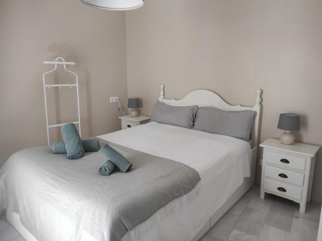 a white bedroom with two beds and a dresser at Plaza Plateros in Jerez de la Frontera
