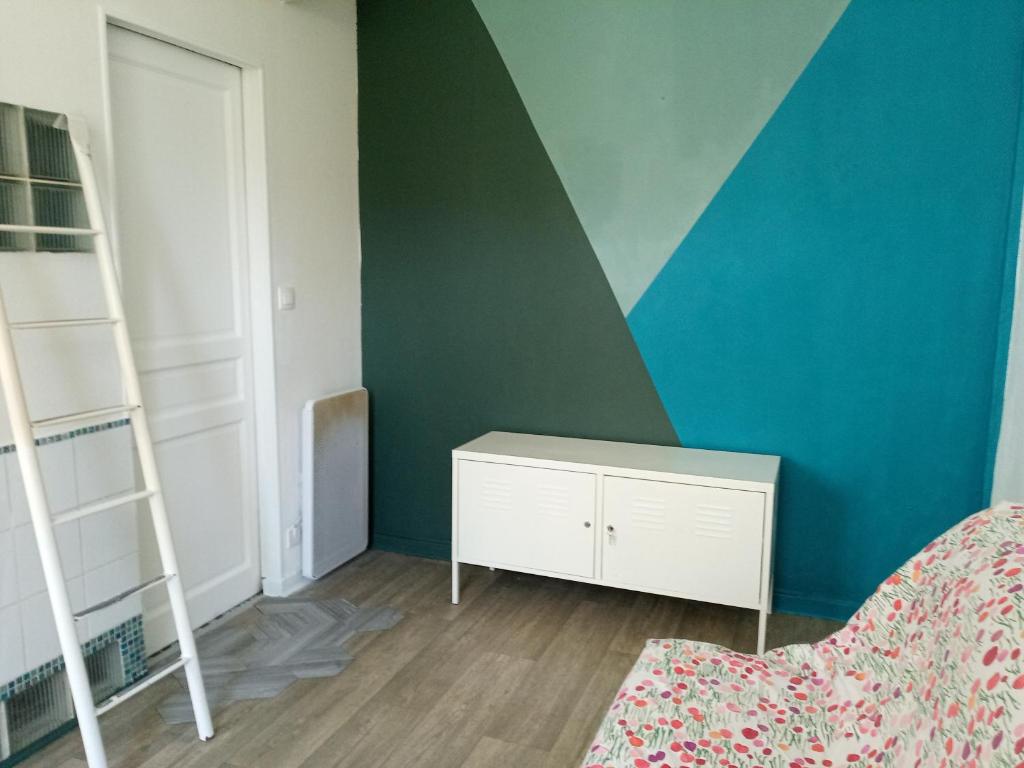 une chambre avec un mur vert et une armoire blanche dans l'établissement Independent studuo close to Paris, à Pantin
