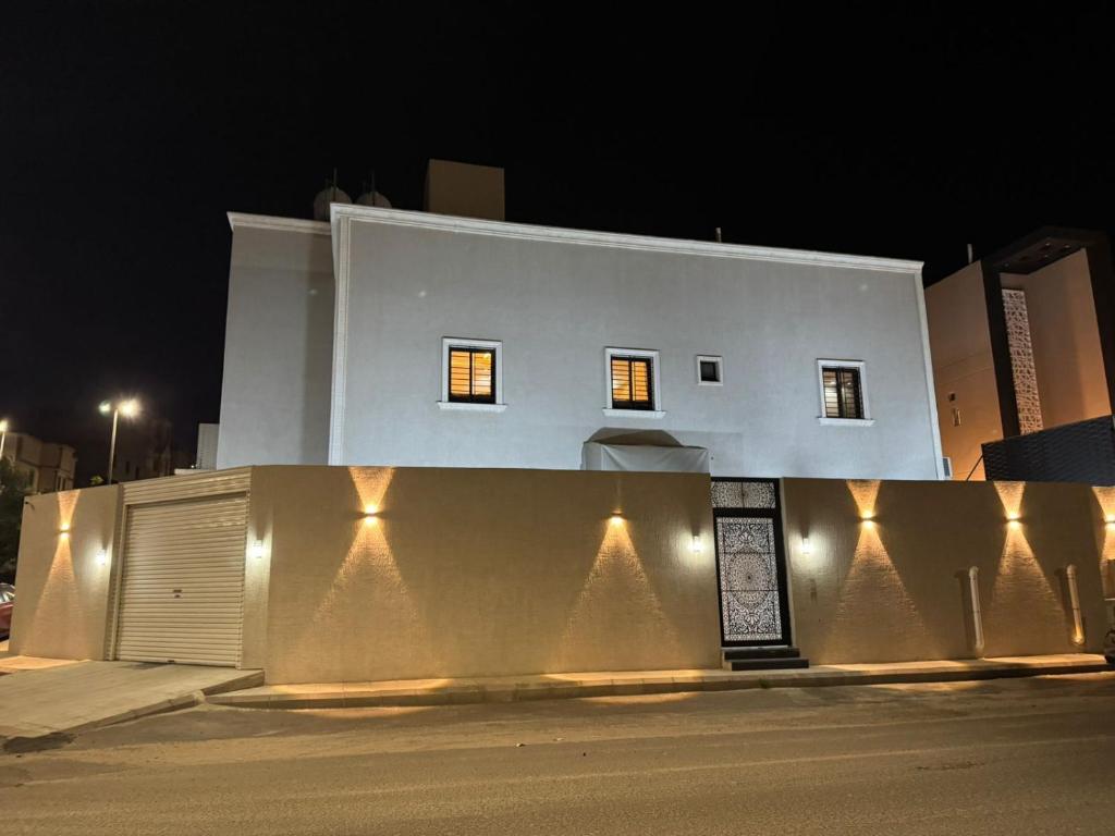 un edificio bianco con luci sul lato di Holiday Home Al Taif Al Wisam a Taif
