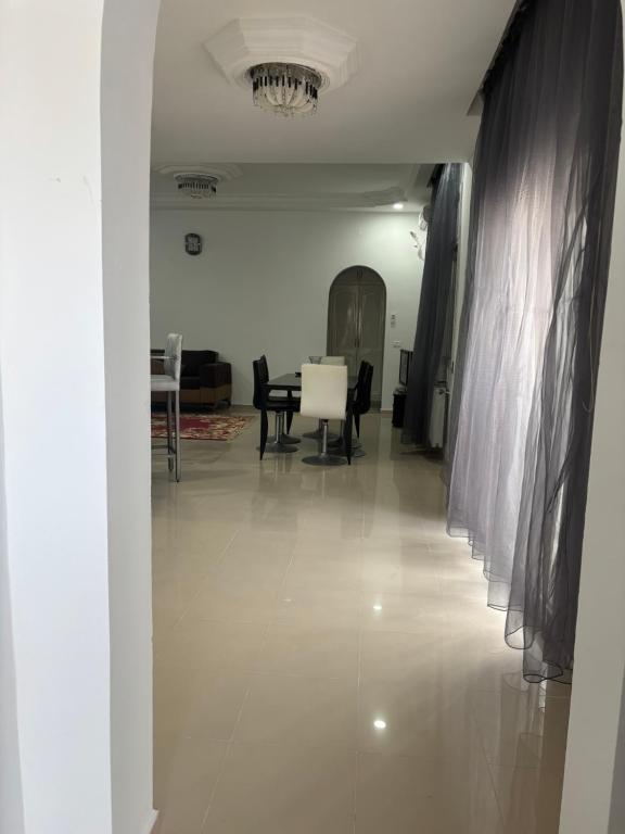 a hallway with a table and chairs in a room at Jinene logement in Yasmine