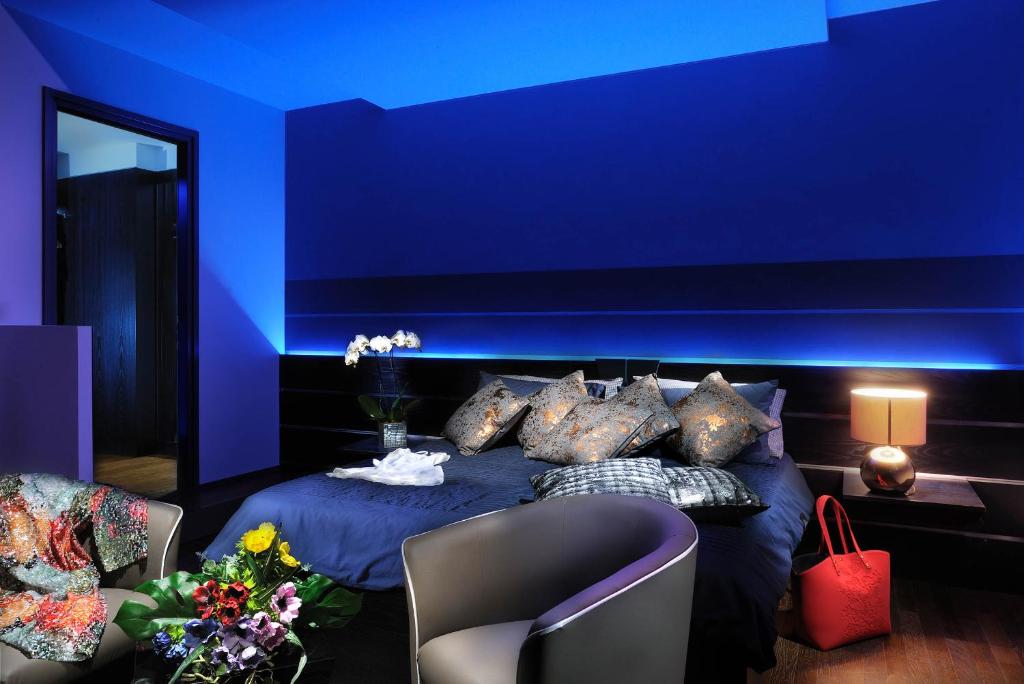 Cette chambre bleue comprend un lit avec des oreillers. dans l'établissement Urban Trend - Guest House, à Palmanova