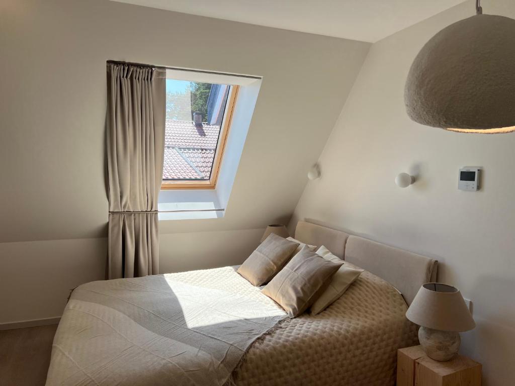a bedroom with a bed and a window at Nida & Sunrise *Self Check-In* in Nida