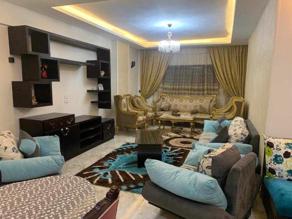 a living room with couches and a couch and a table at شقة للإيجار اليومي مفروشه سوبر لوكس in Manshīyat as Sādāt