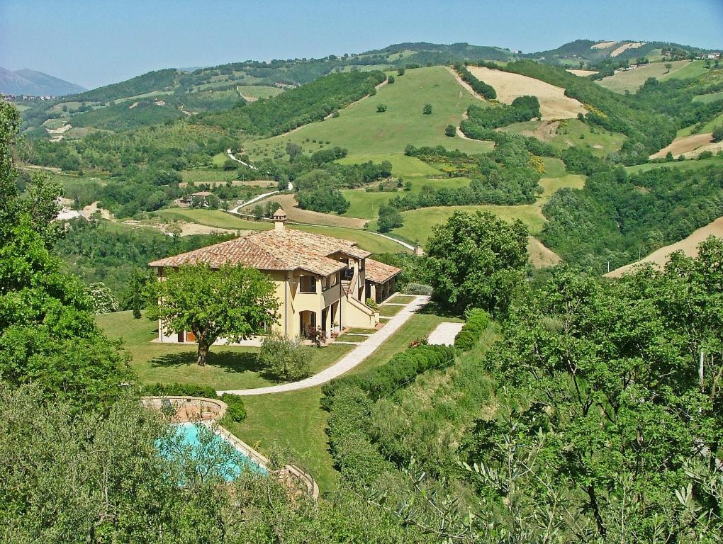 a house on a hill with a road leading up to it at Agriturismo Castagna Alta in Valfabbrica