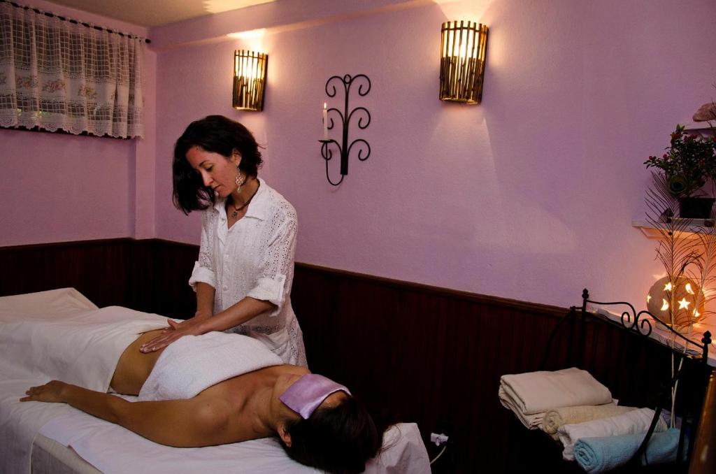 a woman putting a woman on a bed at Hotel Bühler in Visconde De Maua