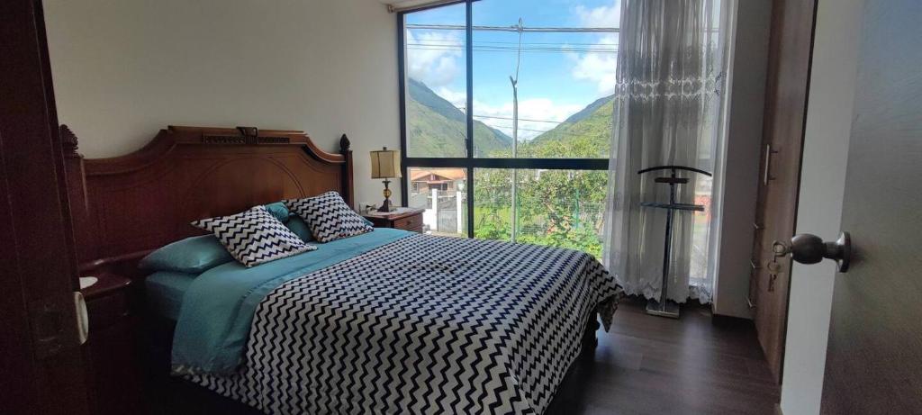 巴尼奥斯Casa TURI, independiente y garage的一间卧室，里面有一张床和一扇大窗户。