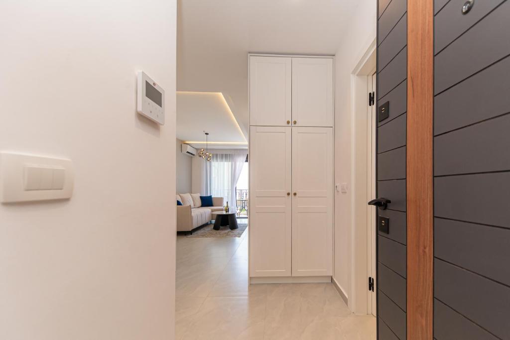 un couloir avec une porte blanche et un salon dans l'établissement Apartment Ejna, à Dobra Voda