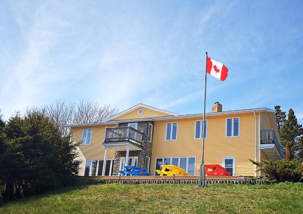 a canadian flag flying in front of a house at 181 Oceanside Inn in Peggy's Cove