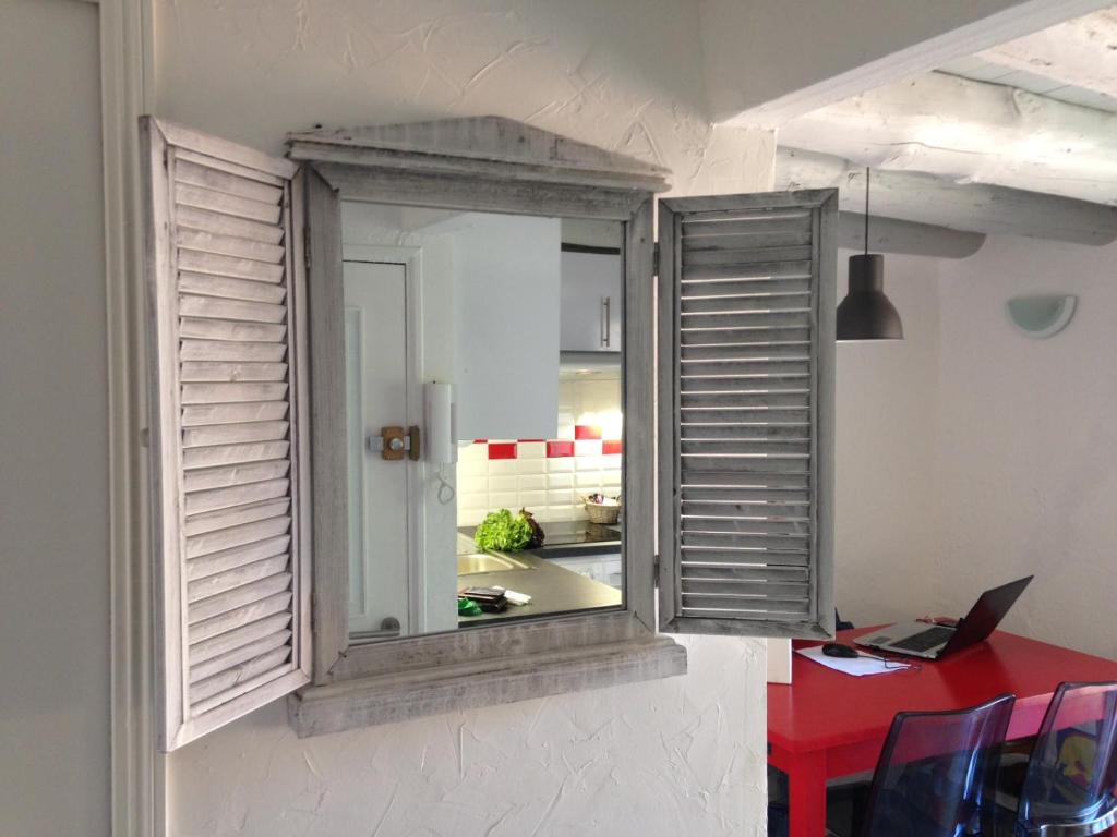 a room with a window and a red table with a laptop at Suquet Charm in Cannes