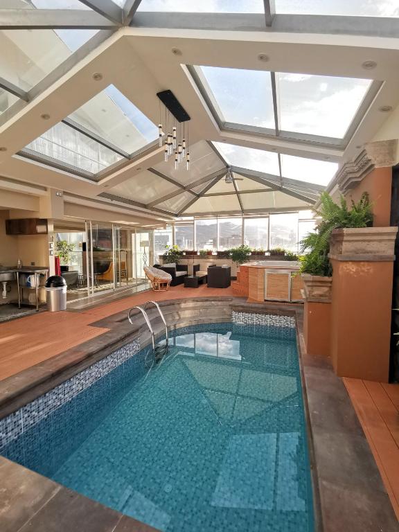 an indoor swimming pool with a ceiling with skylights at Suites Cusco in Cusco