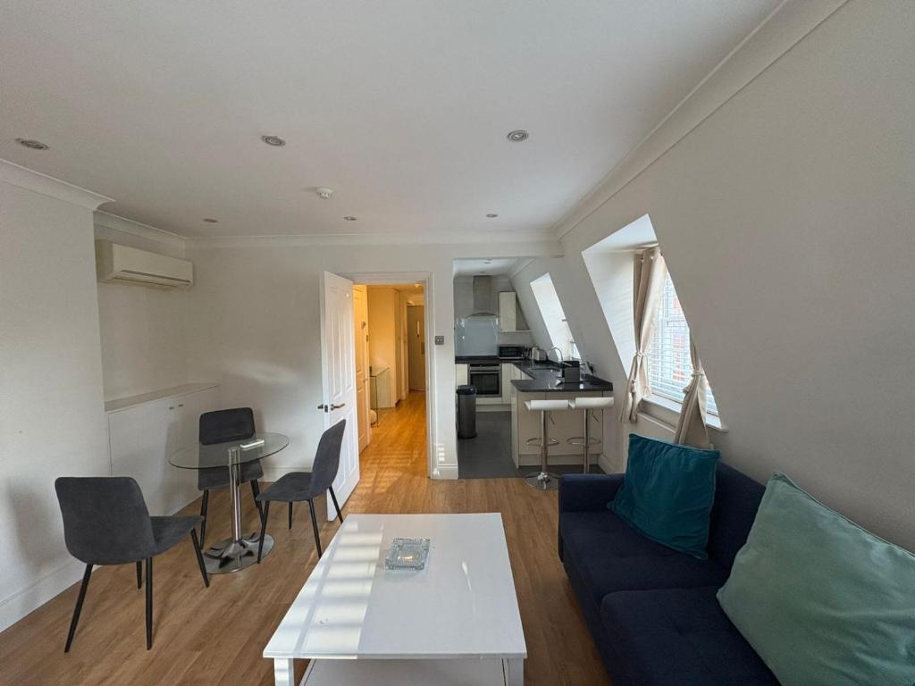a living room with a blue couch and a table at The Orderly By Estatesmen in London