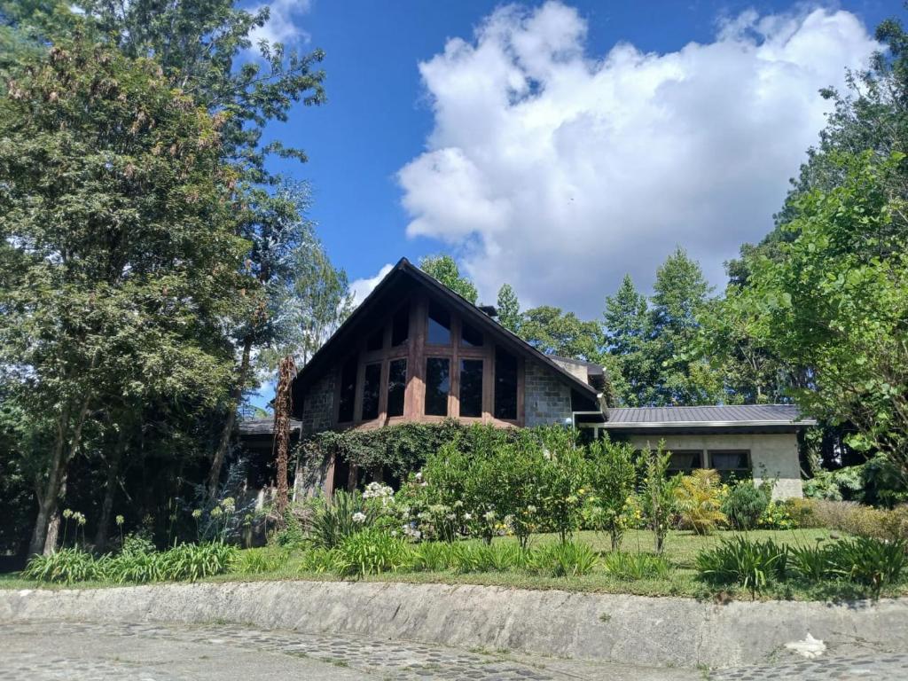 a house with a garden in front of it at Casa Campestre Lomas de Holanda in Santa Cruz Verapaz