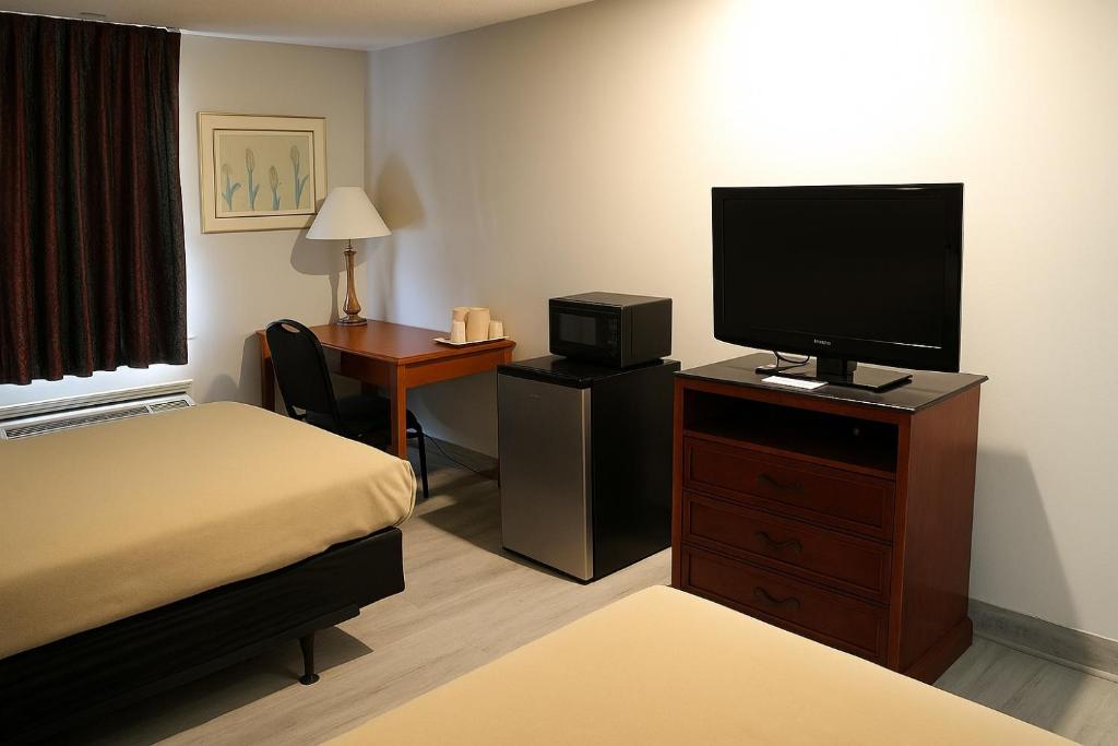 a hotel room with a bed and a flat screen tv at Raceway Inn in Darlington