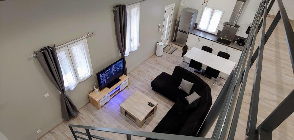 - un salon avec un canapé et une télévision dans l'établissement Appartement T5 meublé 110 m2 neuf proche centre ville, à Nîmes
