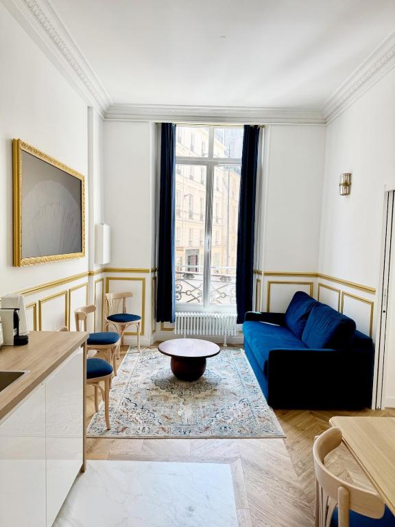 un salon avec un canapé bleu et une table dans l'établissement Richelieu Charm center of Paris, à Paris