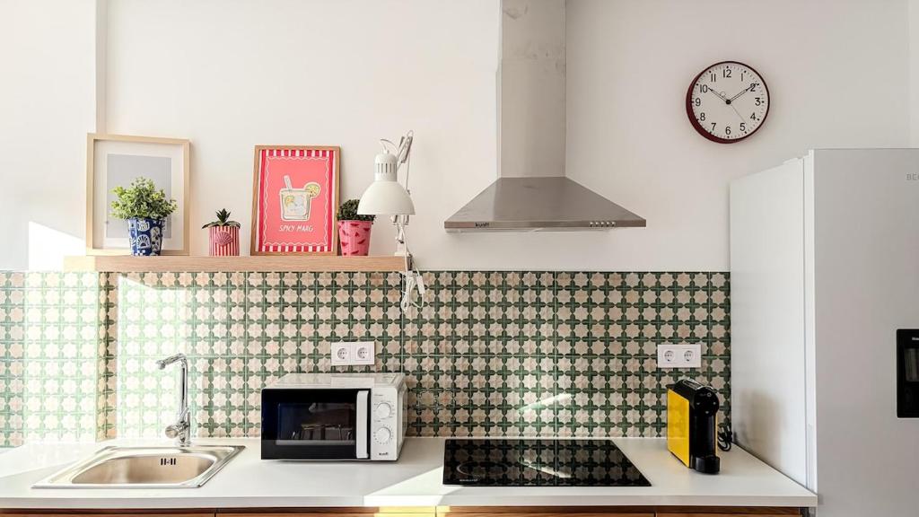 una cucina con un lavandino e un microonde su un bancone di Vizinho -Central - perto praia - Wi-Fi a Setúbal