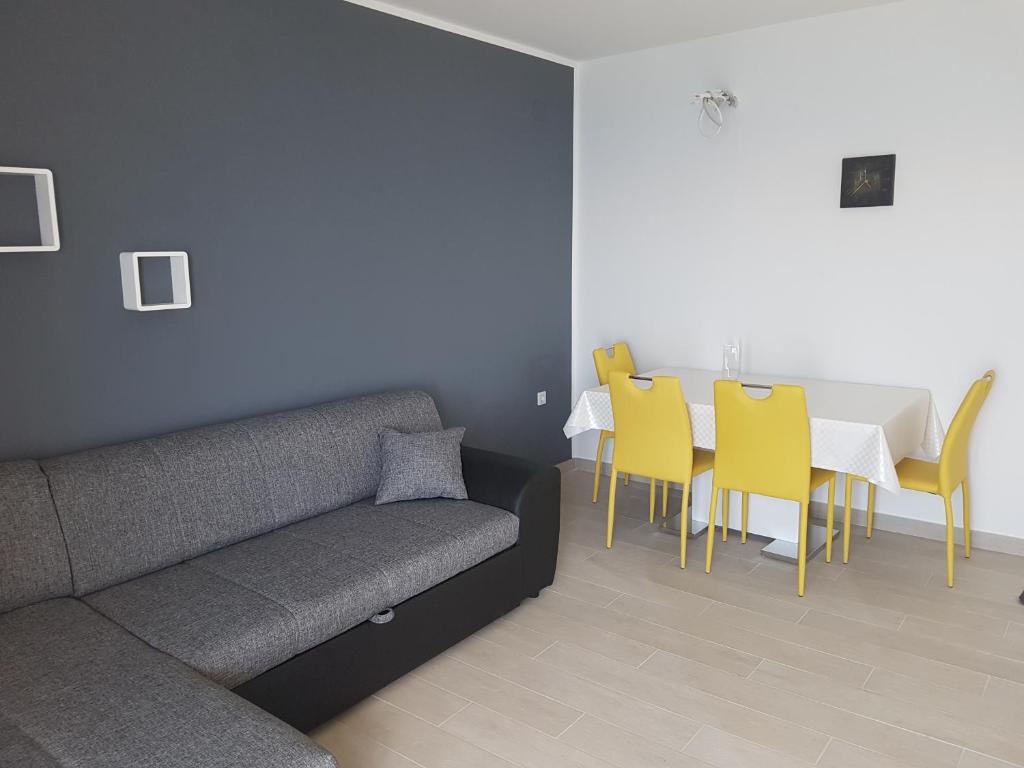a living room with a couch and a table and chairs at Apartments Tereza in Senj