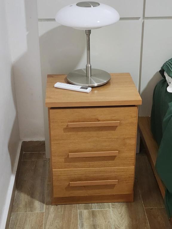 a night stand with a lamp on top of it at Residencias crasky in Punta Cana