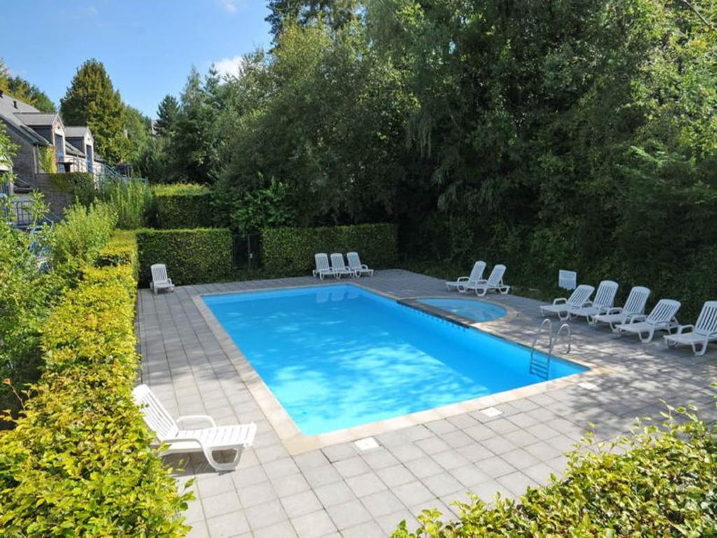 a swimming pool with lounge chairs and a swimming pool at Apartment in Durbuy near Ourthe River in Durbuy