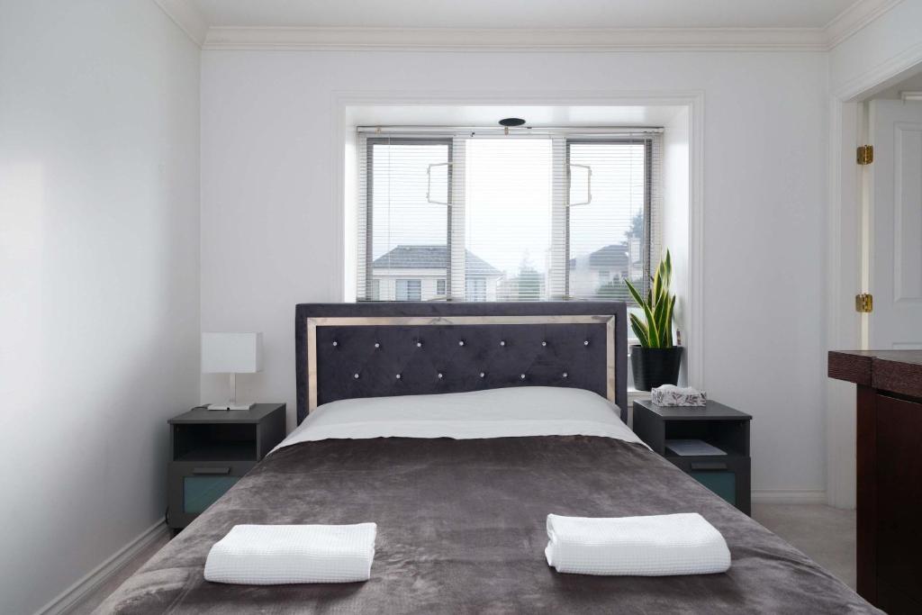a bedroom with a large bed with two night stands at Spacious Room with Private Washroom in Homestay in Vancouver