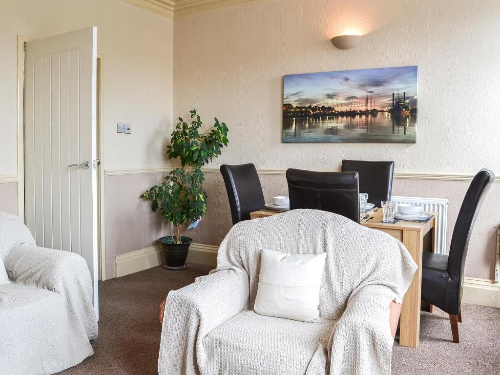 a waiting room with a chair and a table at White Rose Apartment in Bridlington