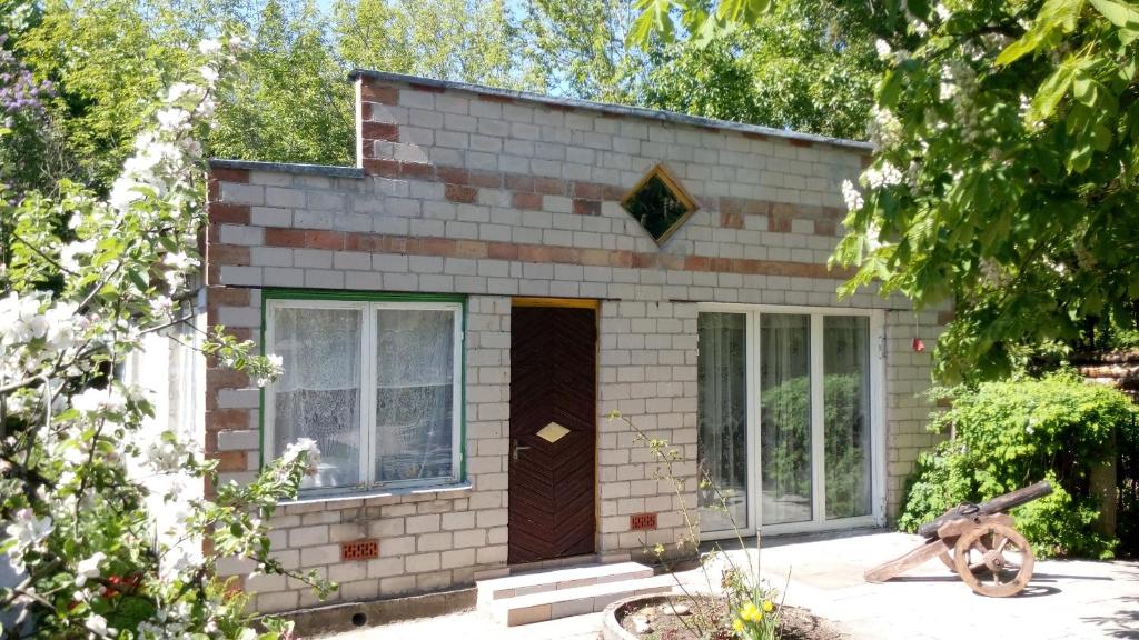 una pequeña casa de ladrillo con puerta marrón en Koidula Holiday Home en Narva-Jõesuu