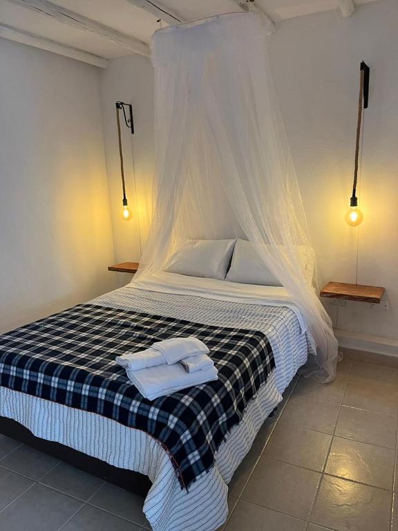 a bedroom with a bed with two towels on it at El Aldabón - Villa de Leyva in Villa de Leyva