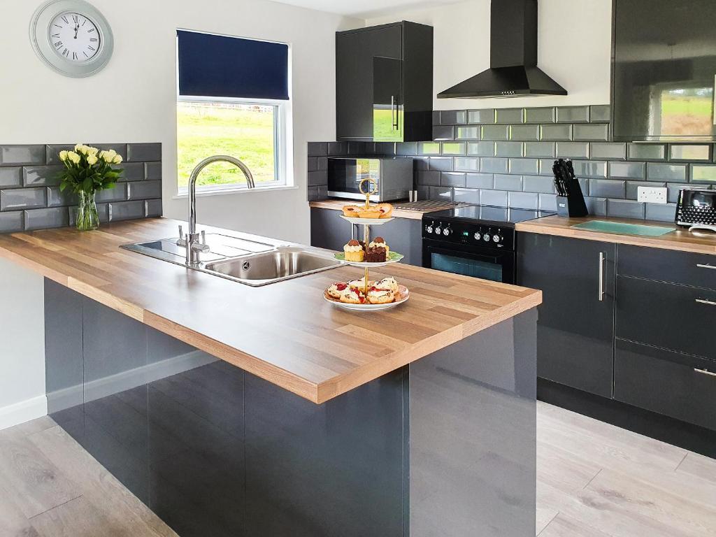a kitchen with a sink and a bowl of fruit on a counter at Rose Lodge - Uk40019 in Halwill