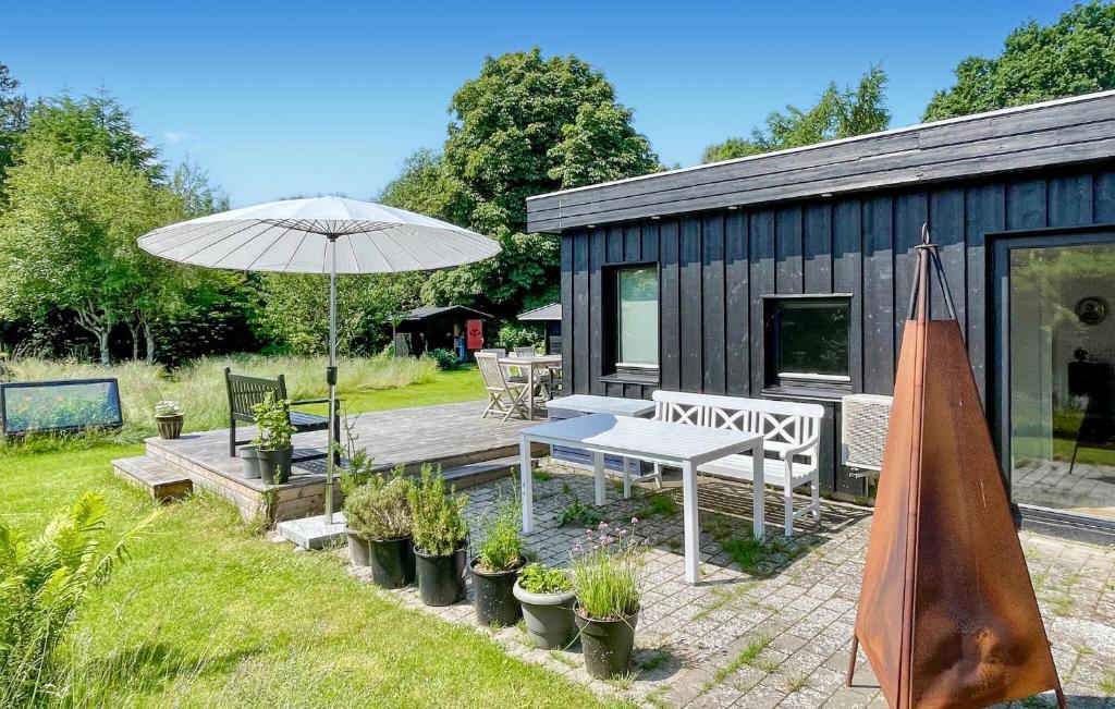 a house with a picnic table and an umbrella at 2 Bedroom Beautiful Home In Gilleleje in Gilleleje