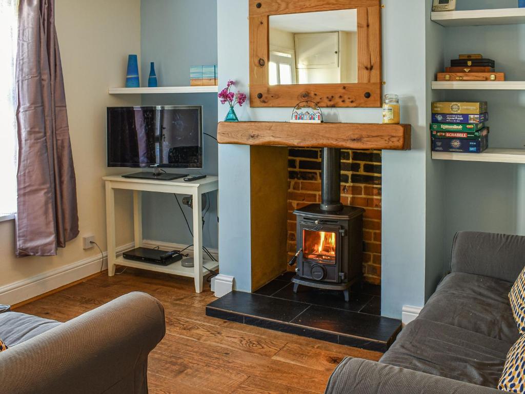 ein Wohnzimmer mit einem Holzofen im Zimmer in der Unterkunft Pakefield Seaview Cottage in Lowestoft