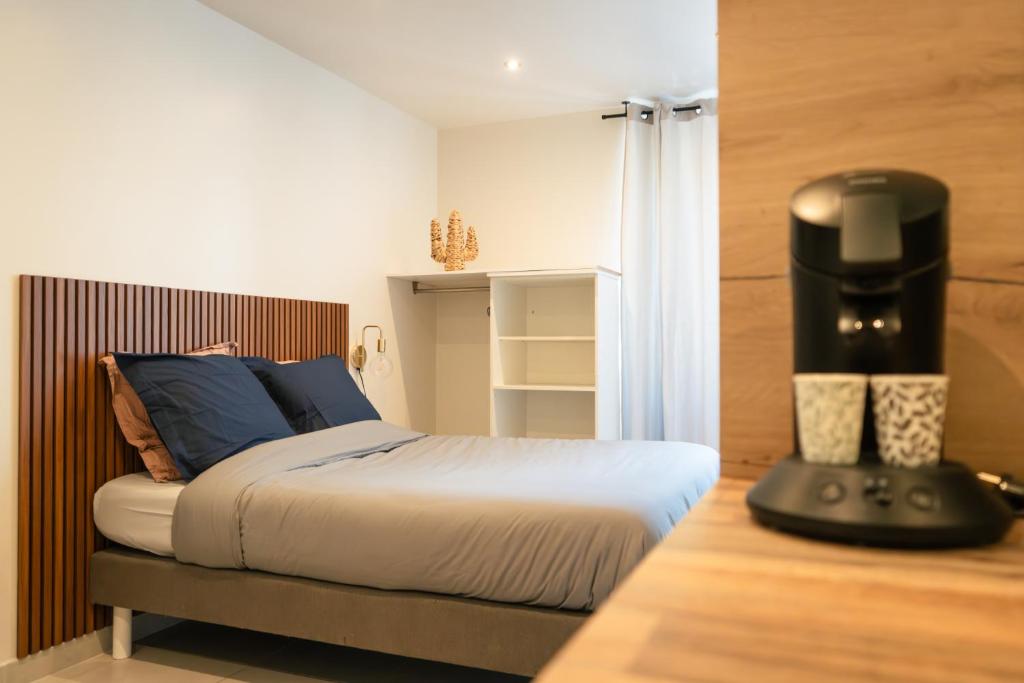 une chambre avec un grand lit et un noir dans l'établissement Charmant Studio avec Parking Gratuit, à Vals-les-Bains