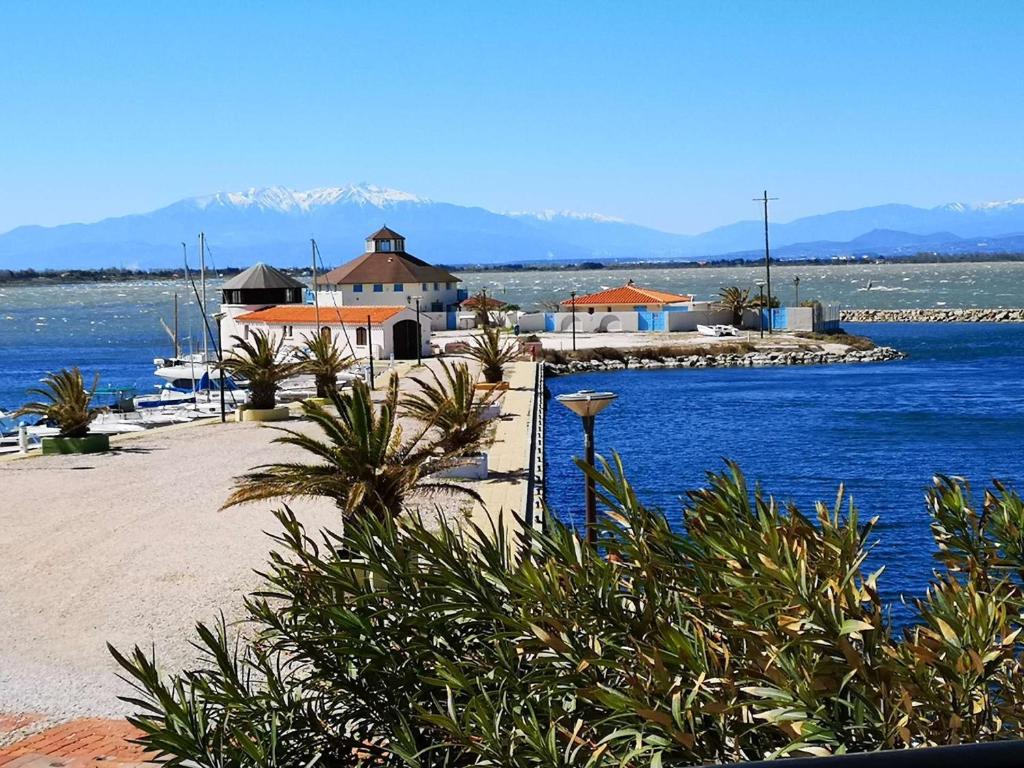 - une plage avec des maisons et une étendue d'eau dans l'établissement Appartement rénové 2 chambres avec parking au Barcarès - FR-1-195-121, au Barcarès