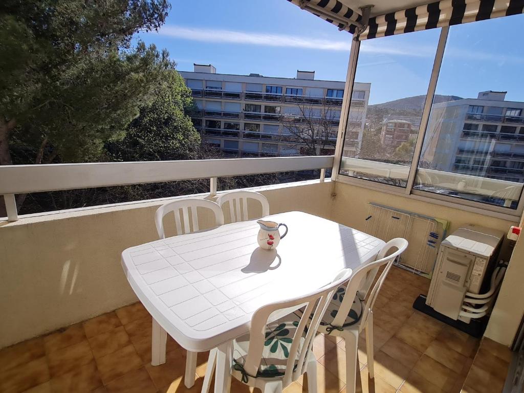 une table blanche et des chaises sur un balcon dans l'établissement Appartement 2 Pièces Climatisé avec Parking en Centre-Ville, Proche Plages - Sainte-Maxime - FR-1-780-54, à Sainte-Maxime