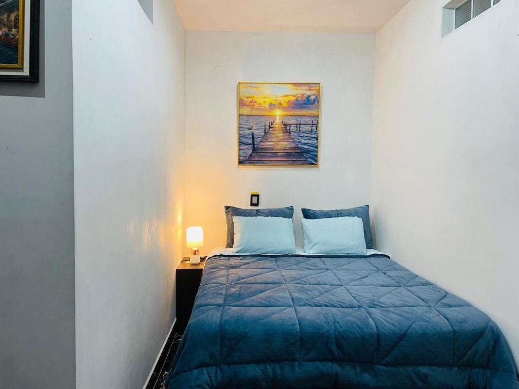 a bedroom with a bed and a painting on the wall at casa borde de lago in Panajachel