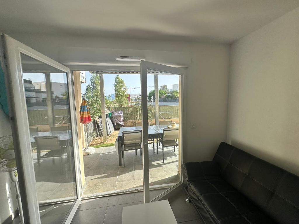 a living room with a couch and a table and a patio at Appartement Perpignan in Perpignan