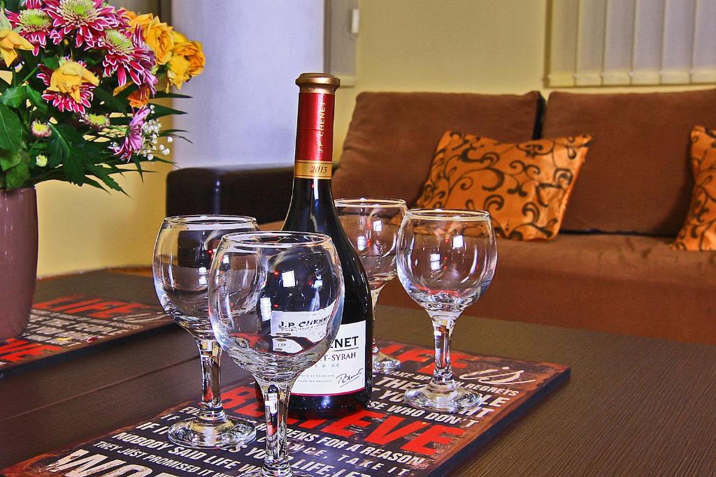 una botella de vino sentada en una mesa con copas de vino en Nirvana Accommodation, en Bucarest