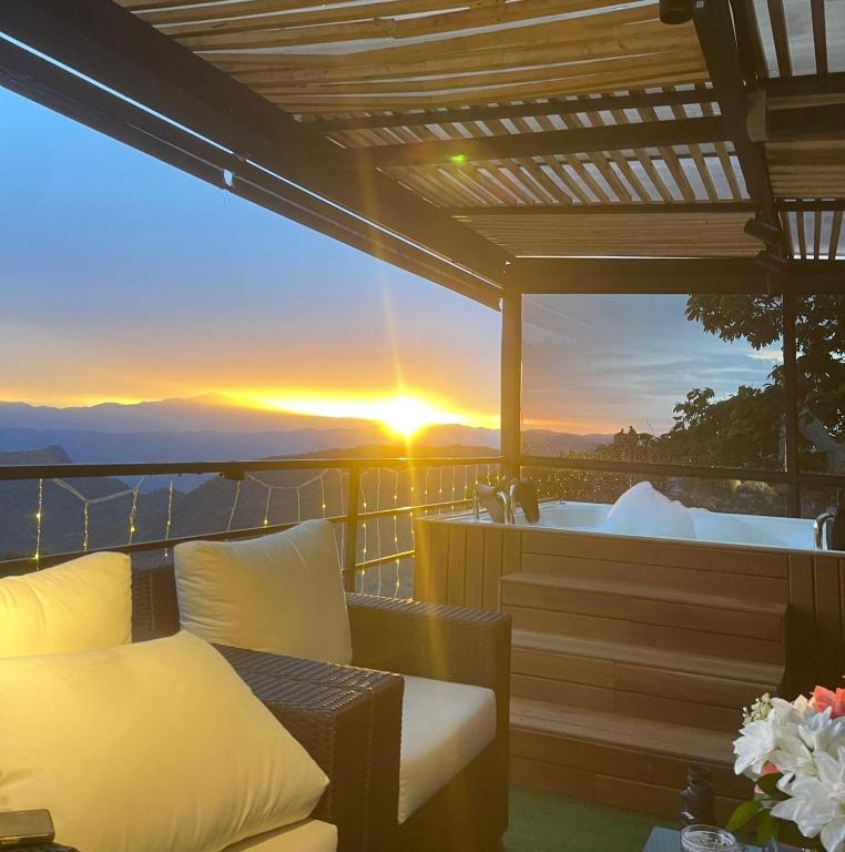 a balcony with a bed and a tub with the sunset at Kcafe Ancestral Glamping in Venecia