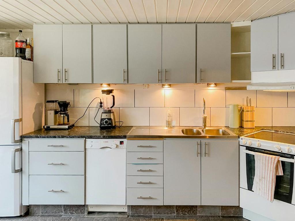 a kitchen with white cabinets and a sink at Lakeside Holiday Home With Sauna Near Karlskoga in Karlskoga