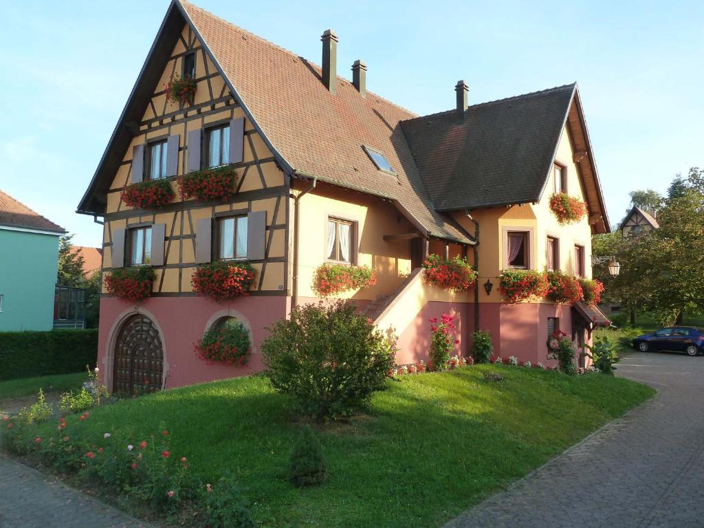 uma casa com caixas de flores na frente em Gitzelbrunnen em Epfig