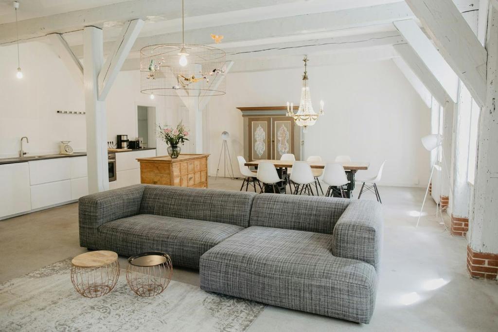 un salon avec un canapé et une table dans l'établissement Loft Under Thatch Retreat In Eiderstedt Nature, à Tetenbüll