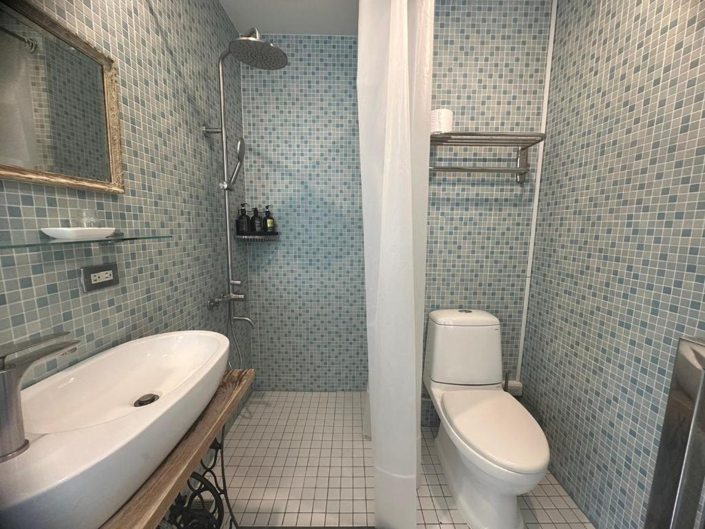 a bathroom with a tub and a toilet and a sink at Hour Roots in Tainan