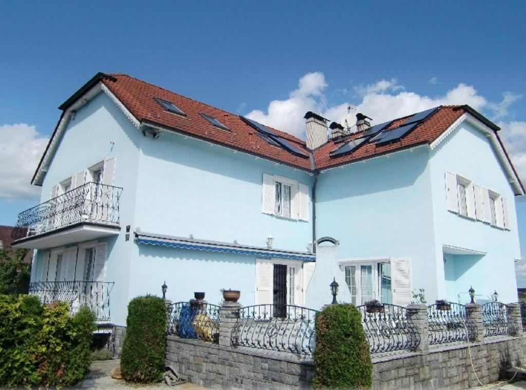 ein weißes Haus mit rotem Dach in der Unterkunft Penzion Buchmann in Franzensbad